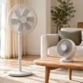 Ventilador de pie y ventilador compacto en un salón luminoso.